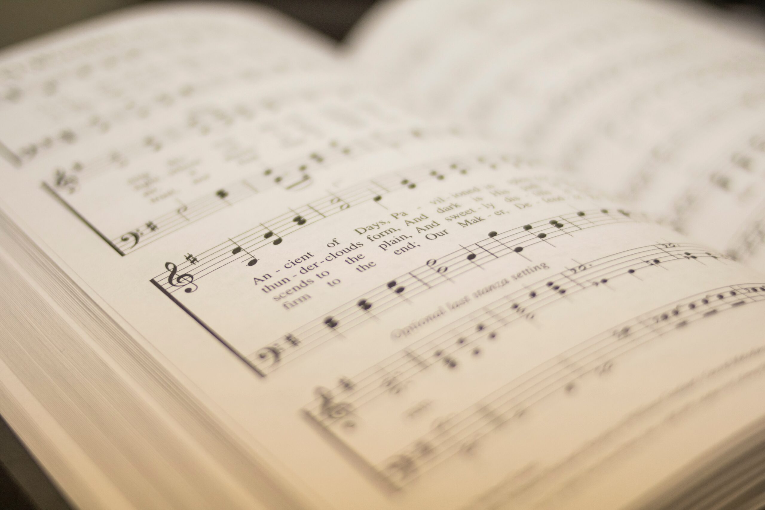 Photo by Michael Maasen on Unsplash. A closeup of a hymnal, open to "O Worship the King" (written by Grant/Haydn)